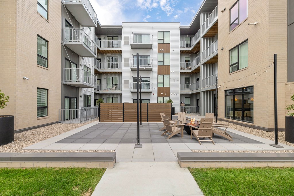 A modern apartment complex with a courtyard and seating area.