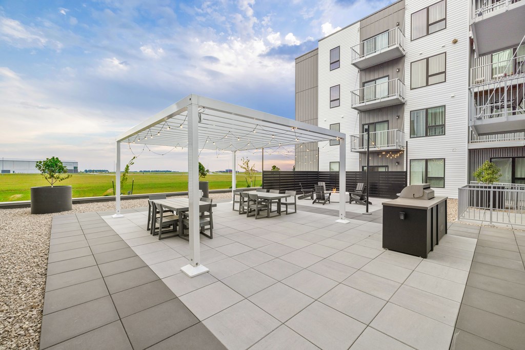 A patio with a table and chairs under a white canopy.
