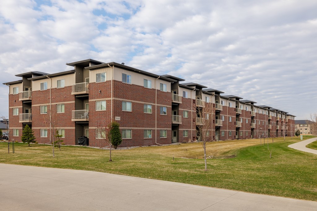 Apartment building with a green lawn in front.