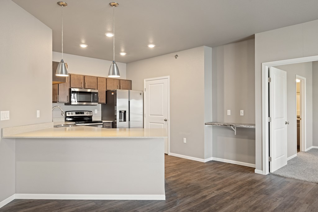A kitchen with a white counter and a microwave on it.