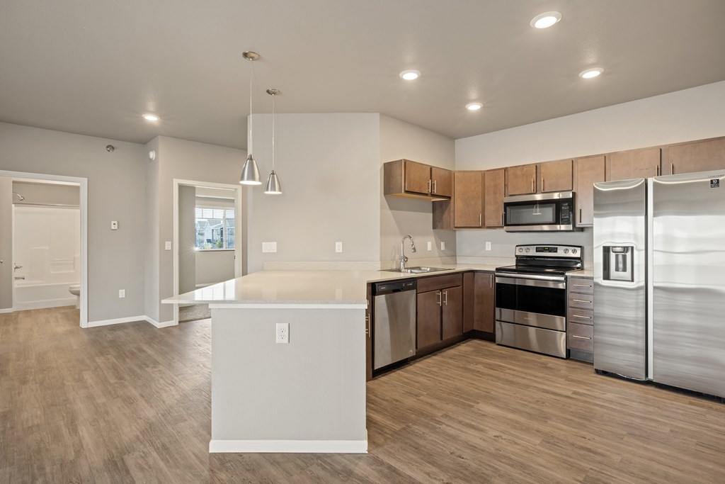 A modern kitchen with stainless steel appliances and wooden cabinets.