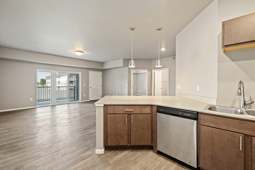 A kitchen with wooden cabinets and a stainless steel dishwasher.