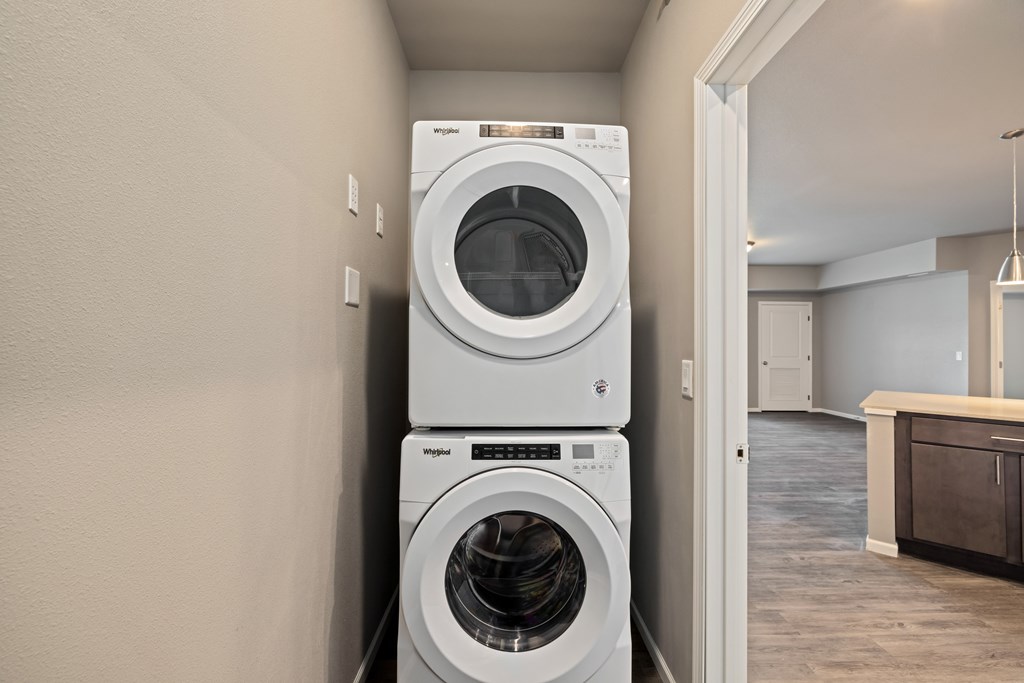 Two white front loading washing machines in a laundry room.