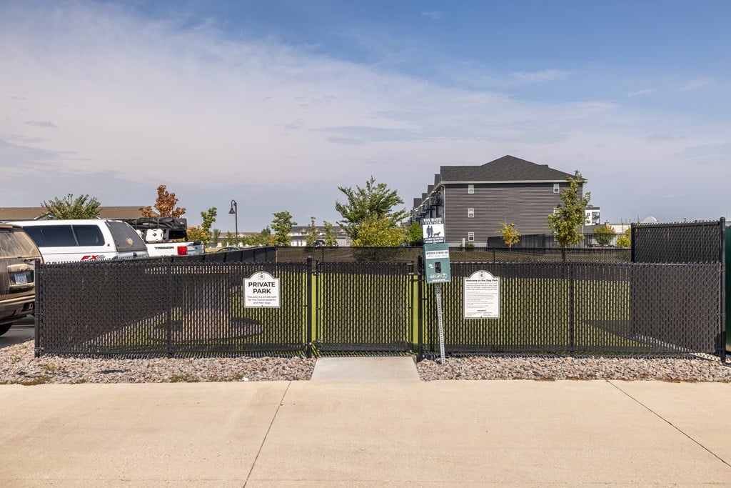 A black fence with a sign that says "PRIVATE PROPERTY NO TRESPASSING" in front of a building.