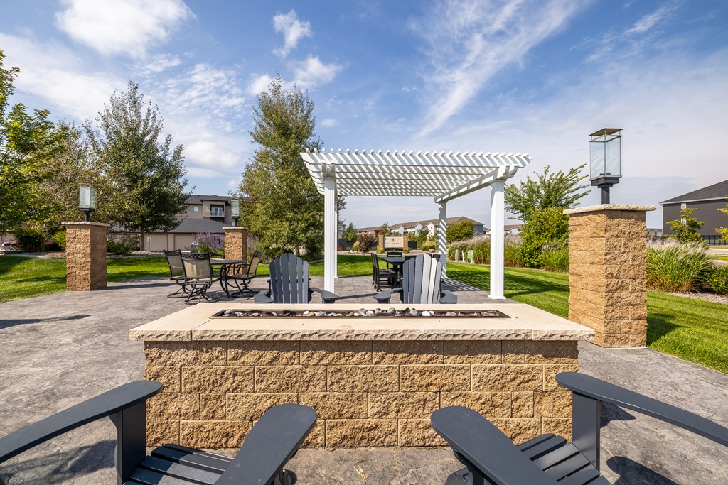 A patio with a fire pit and seating area.
