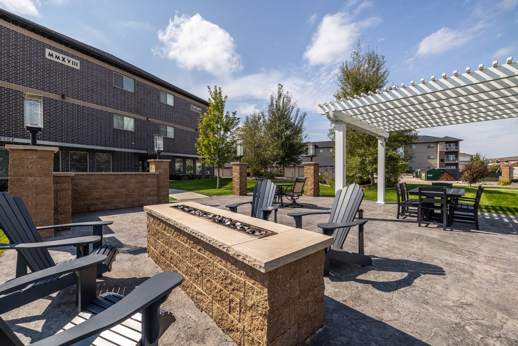 A patio area with a fire pit and seating.