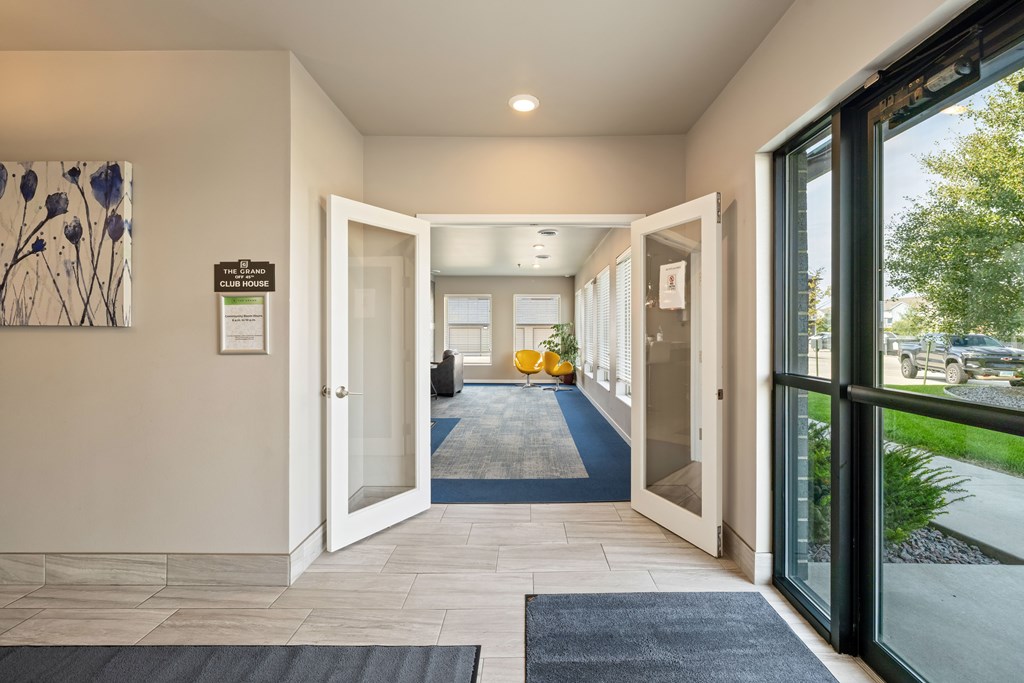 A hallway with a blue carpet and white walls.