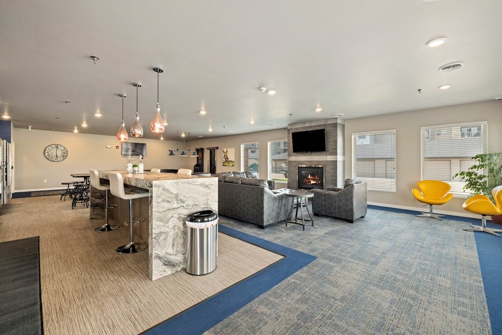 A modern office space with a fireplace, chairs, and a TV.