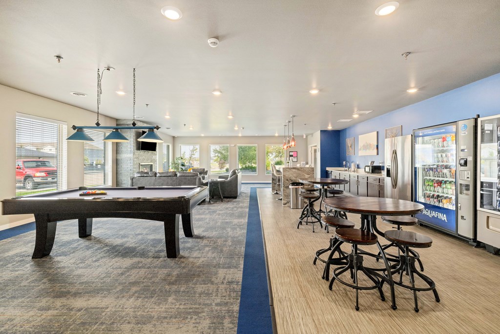 A billiard table is in the middle of a room with a blue carpet.