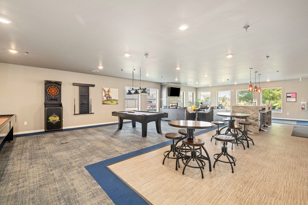 A large room with tables and chairs and a blue rug.