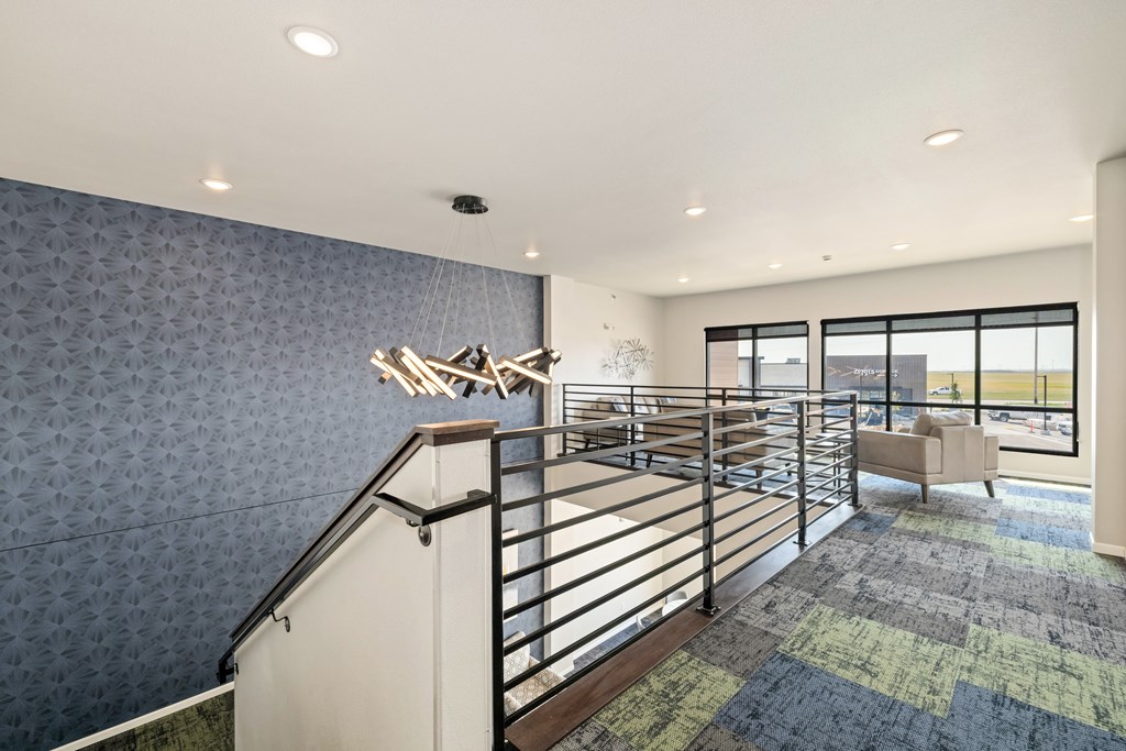 A staircase with a metal railing and a patterned carpet.