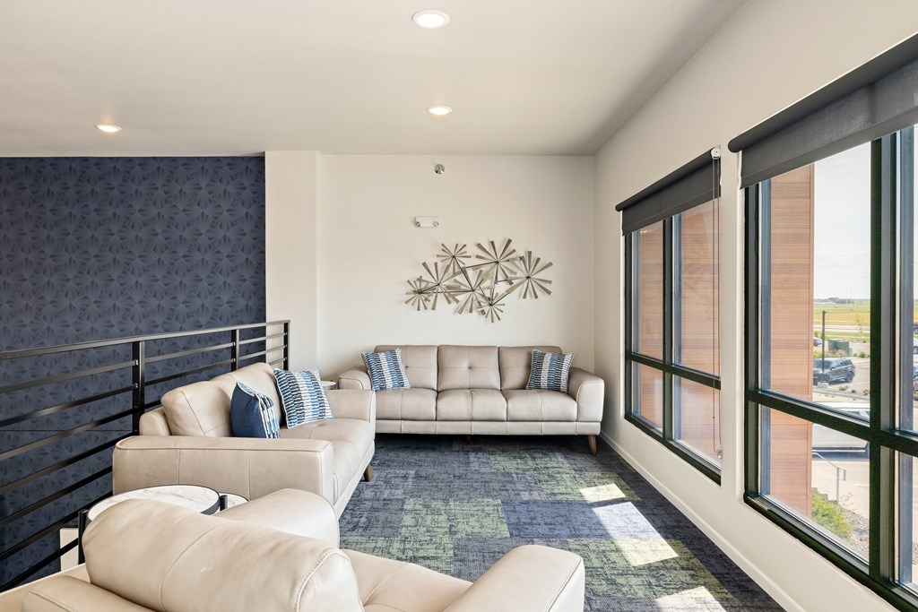 A living room with a large window and a sofa set.