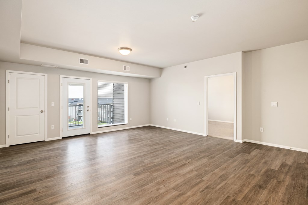 A large empty room with wooden floors and white walls.