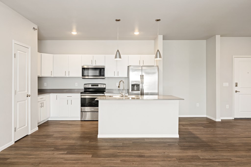 A modern kitchen with a white island and stainless steel appliances.