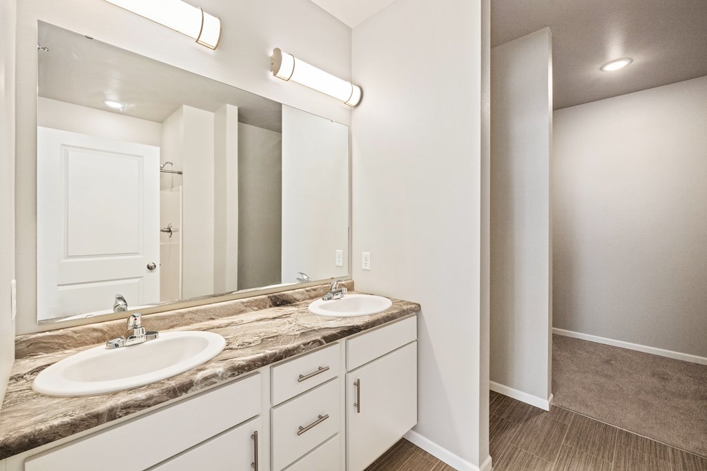 A bathroom with a double sink and a large mirror.