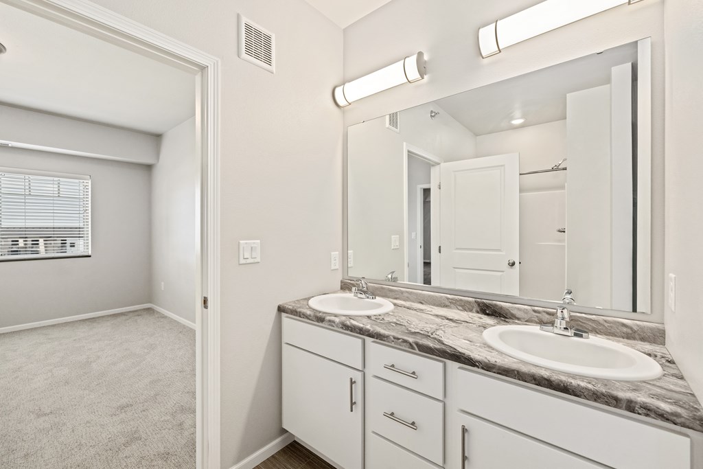 A bathroom with a sink, mirror, and carpeted floor.