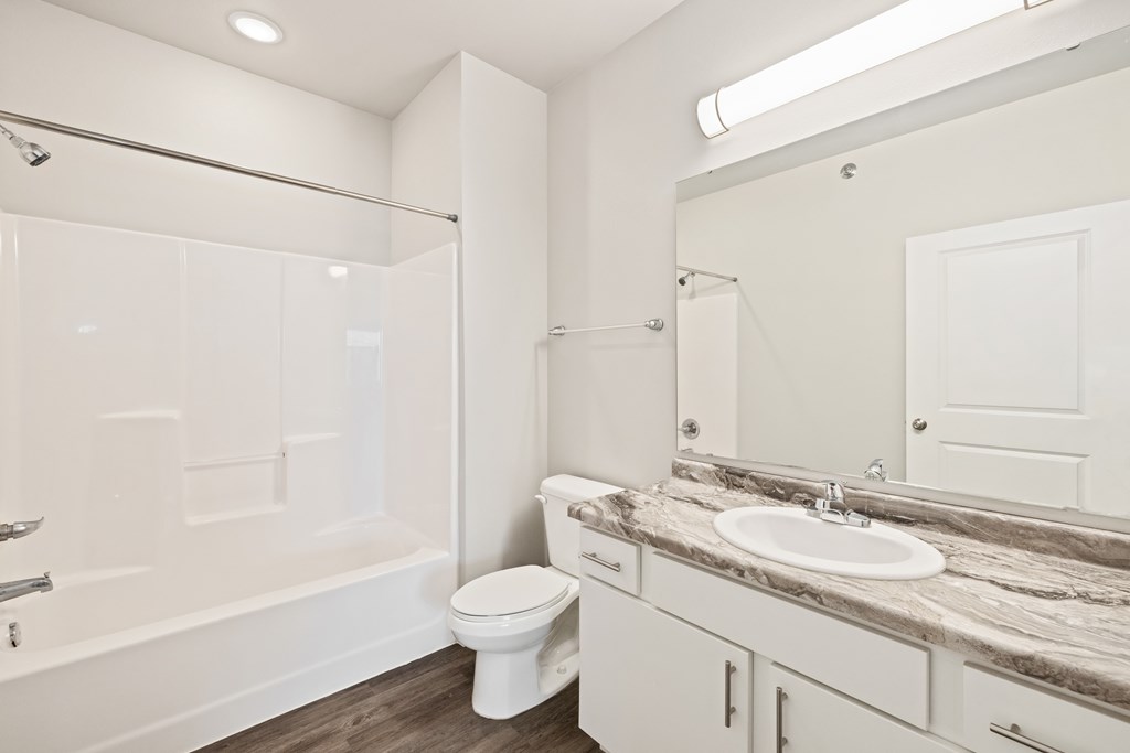 A white bathroom with a toilet, sink, and bathtub.