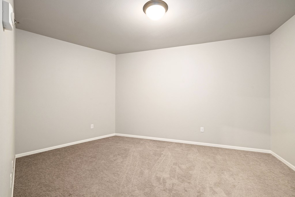 A room with a carpeted floor and a ceiling light.