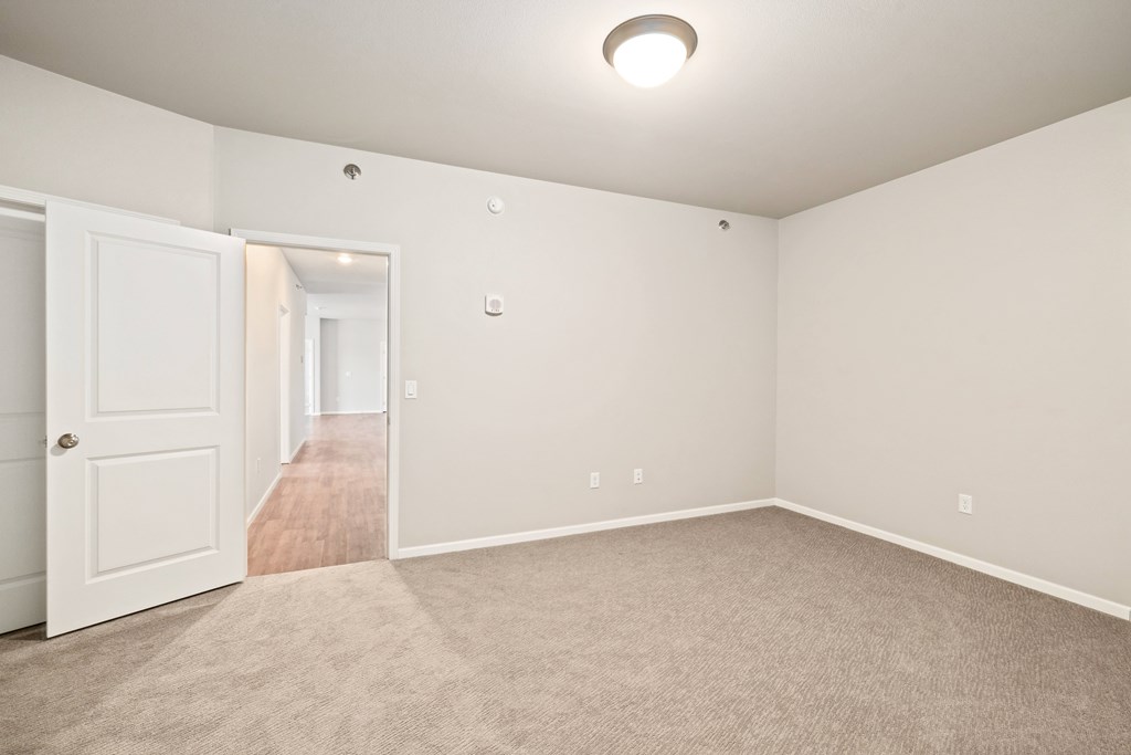 A room with a carpeted floor and a white door.