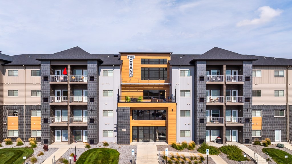 The Howard apartment complex has a modern design with a mix of grey and wood accents.