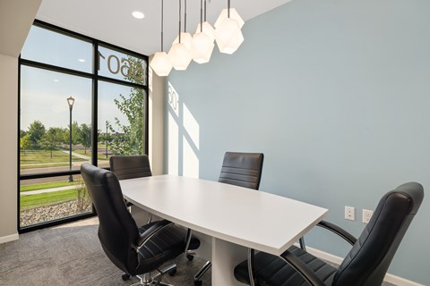 A conference room with a table and chairs.
