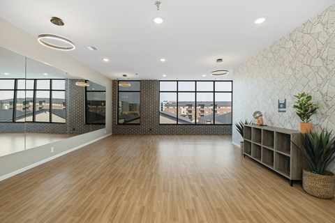 A room with wooden floors and a large window overlooking a cityscape.