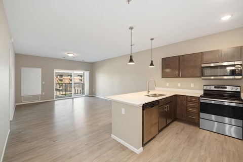 A kitchen with a white countertop and wooden cabinets.