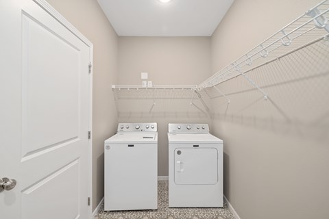 A white door is on the left of a wall-mounted clothes dryer.