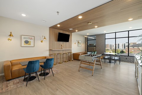 A living room with a brown couch, blue chairs, and a wooden table.