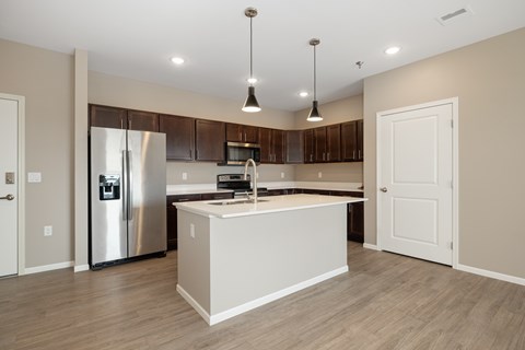 A modern kitchen with a stainless steel refrigerator and wooden cabinets.
