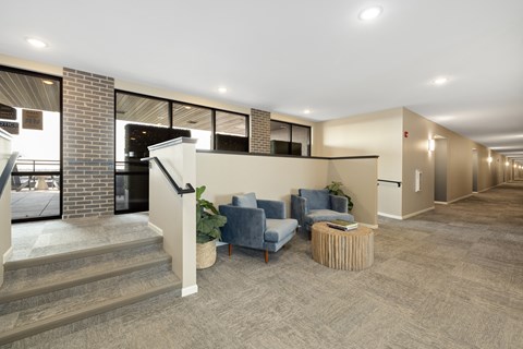 A spacious hallway with a staircase and seating area.