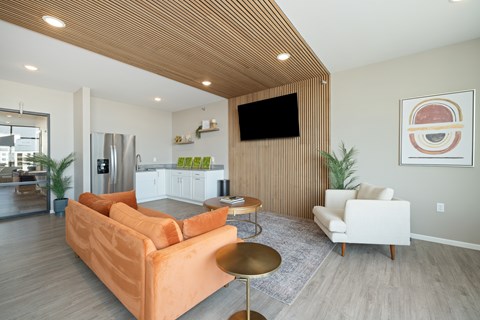 A living room with a couch, chair, and television.