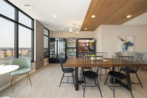 A room with a table and chairs and a fridge.