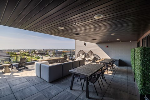 A patio with a table and chairs overlooking a cityscape.