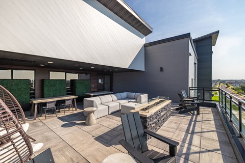 A modern outdoor seating area with a white roof and a glass wall.