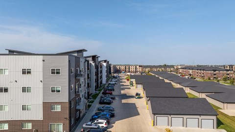 A row of modern apartment buildings with cars parked in the driveways.