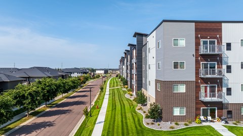 A row of modern apartment buildings with green lawns in front.