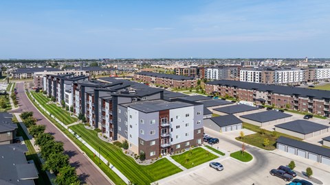A large apartment complex with a parking lot in front.