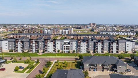 A large apartment complex with a parking lot in front.