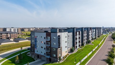 A long row of apartment buildings with a road in front.