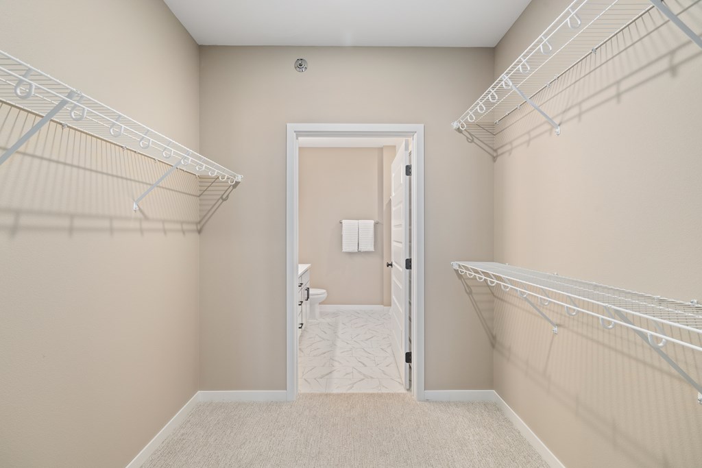 A room with a white door and a carpeted floor.