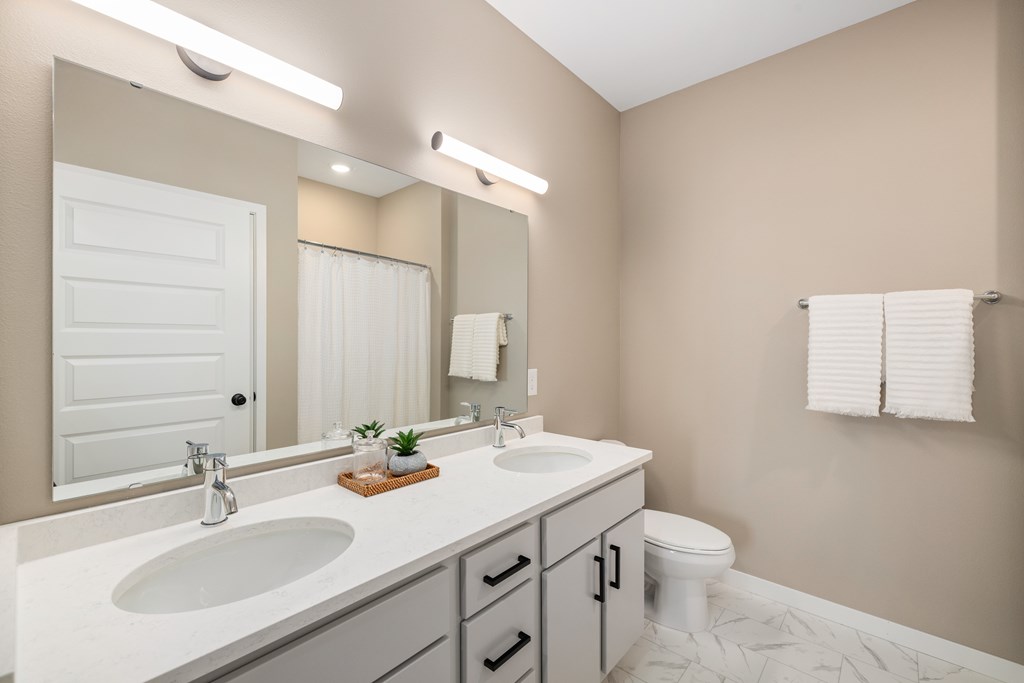 A bathroom with a white sink and a white toilet.