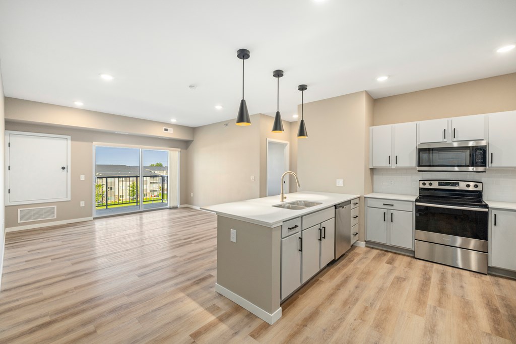 A kitchen with a sink, stove, and oven.