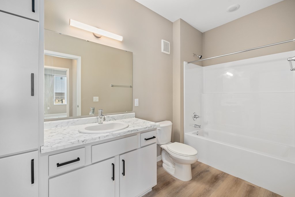A white bathroom with a sink, toilet, and bathtub.