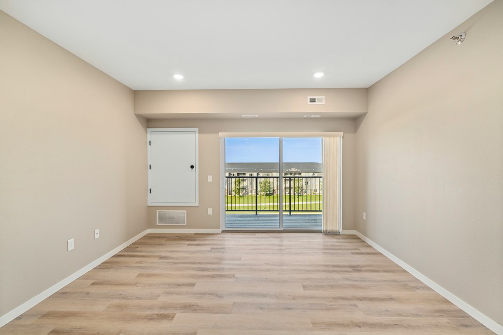A room with a sliding glass door leading to a balcony.