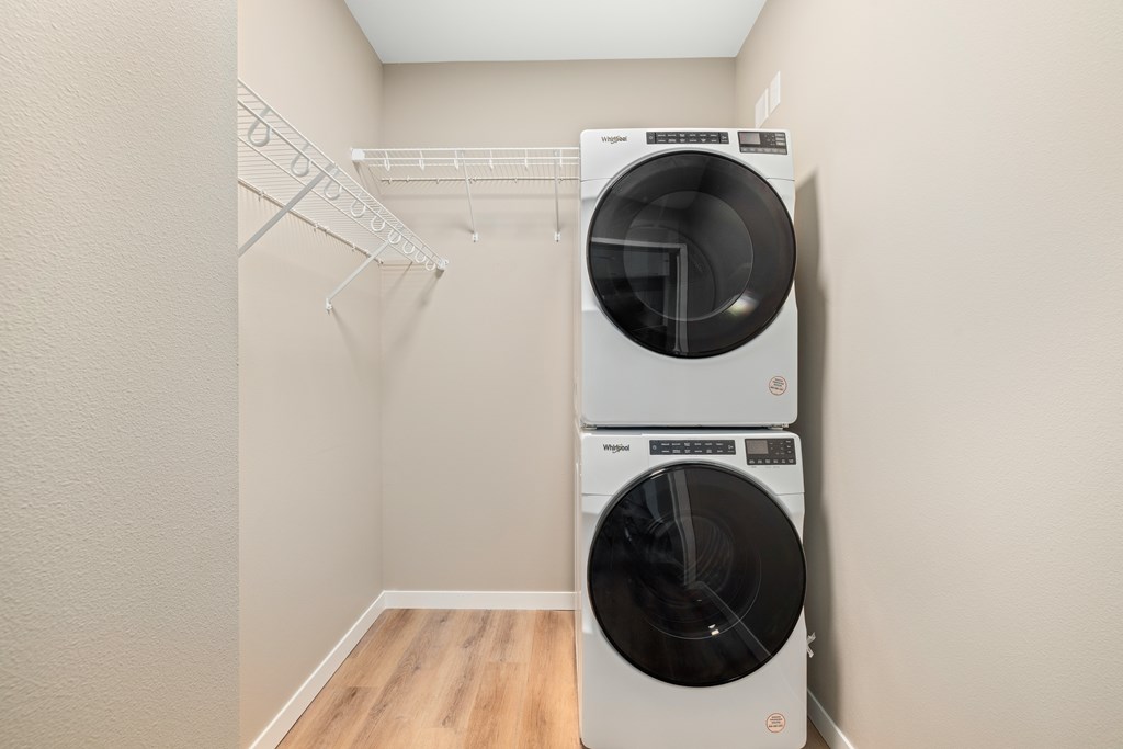 Two white front loading washing machines in a laundry room.
