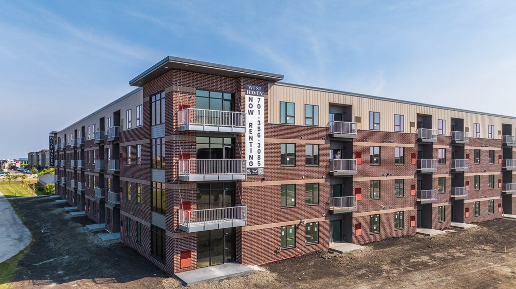 A modern apartment complex with balconies and multiple stories.