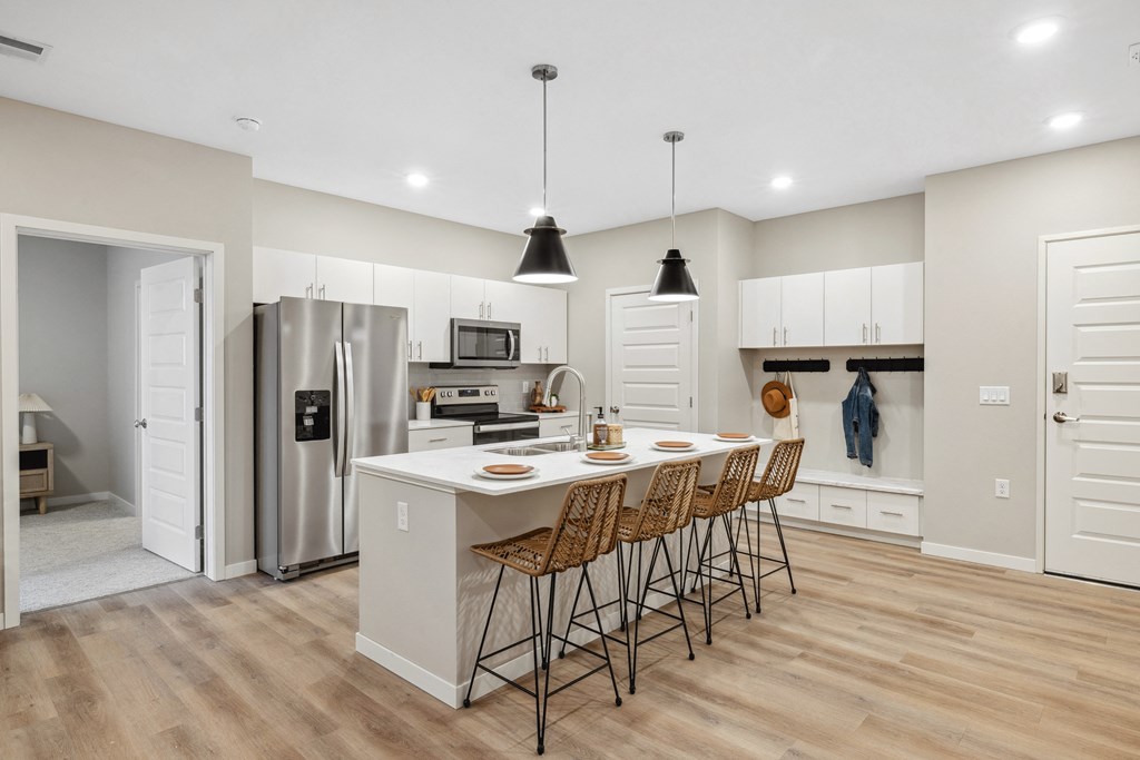 an open kitchen with a large island with bar stools