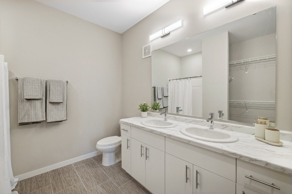 a bathroom with a large mirror and a toilet and sink