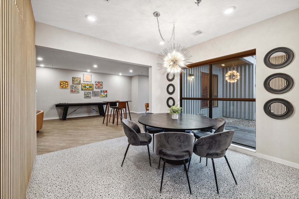 a dining area with a round table and chairs and a glass sliding door